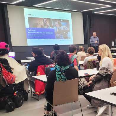 Roger Gassert welcoming the audience in a filled lecture room