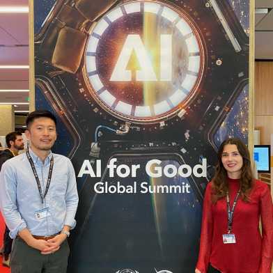 two people in front of a poster with the inscription AI for Good