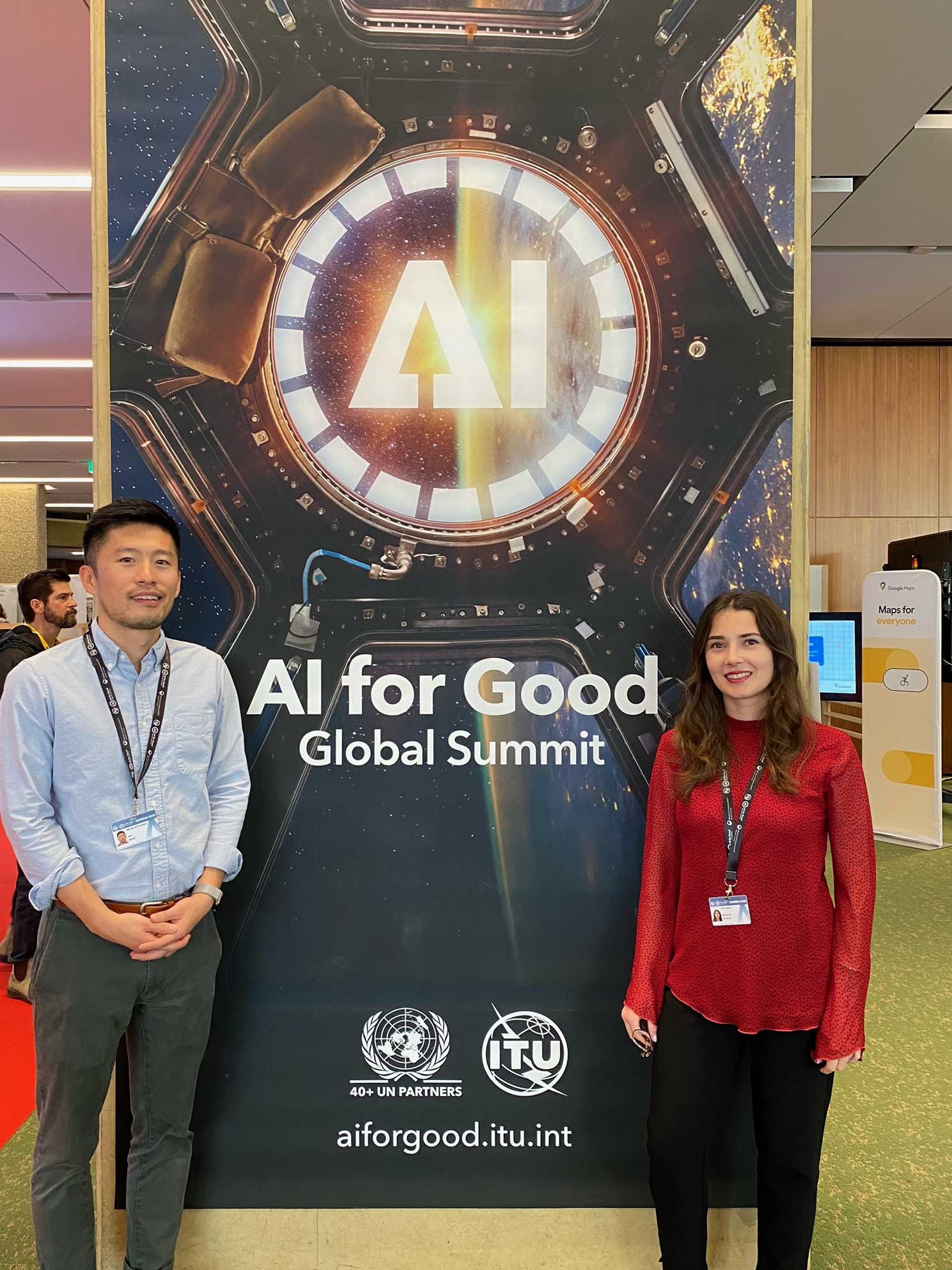 Enlarged view: two people in front of a poster with the inscription AI for Good