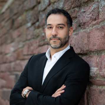Enlarged view: Portrait of Lorenzo Masia in front of al brick wall